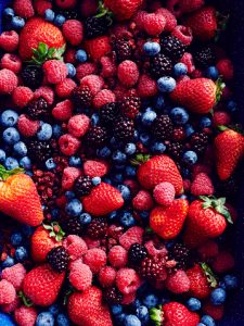 Still life with abundance of strawberries, blackberries, blueberries, raspberries and cranberries